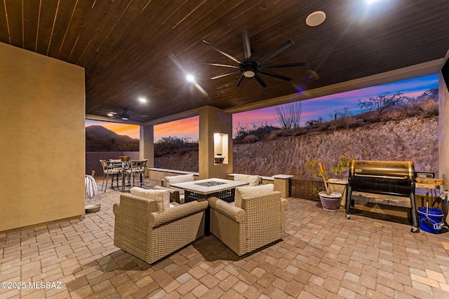 3188 W Tumamoc Dr, Tucson, AZ 85745 - patio terrace at dusk featuring a ceiling fan, a fire pit, outdoor dining area, a patio, and a grill
