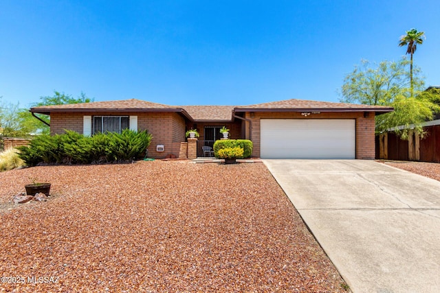 1717 S Burning Tree Ave, Tucson, AZ 85710 - ranch-style home featuring brick siding, an attached garage, concrete driveway, and a shingled roof