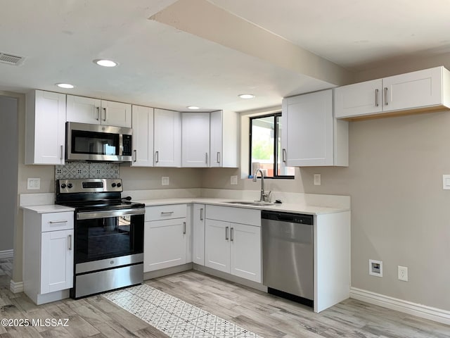 2973 S Kolb Rd, Tucson, AZ 85730 - kitchen with appliances with stainless steel finishes, light wood-style flooring, light countertops, white cabinetry, and recessed lighting