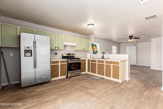 5482 S Monrovia Ave, Tucson, AZ 85706 - kitchen featuring appliances with stainless steel finishes, a peninsula, under cabinet range hood, green cabinetry, and light wood-style flooring