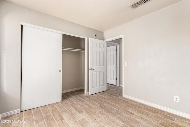 5482 S Monrovia Ave, Tucson, AZ 85706 - unfurnished bedroom featuring light wood-style flooring and a closet