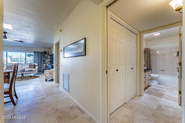1148 W Circulo Del Norte, Green Valley, AZ 85614 - hallway featuring a textured ceiling and light stone finish flooring