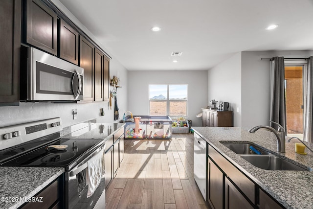 13331 N Carbine Ct, Marana, AZ 85653 - kitchen with stainless steel appliances, wood finished floors, recessed lighting, stone countertops, and tasteful backsplash