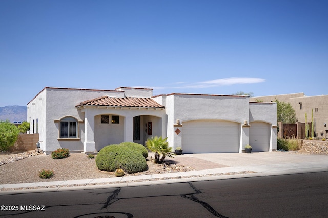3923 S Camino Ensenada Del Pantano, Tucson, AZ 85730 - mediterranean / spanish home featuring an attached garage, concrete driveway, stucco siding, and a tile roof