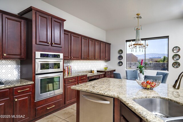 3923 S Camino Ensenada Del Pantano, Tucson, AZ 85730 - kitchen featuring stainless steel appliances, dark brown cabinets, decorative backsplash, and a chandelier