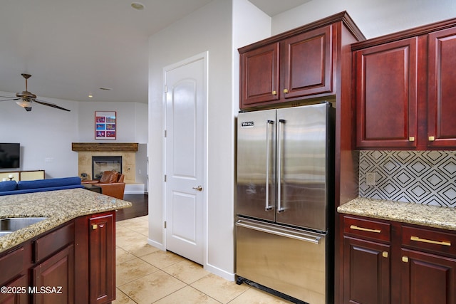 3923 S Camino Ensenada Del Pantano, Tucson, AZ 85730 - kitchen featuring high end fridge, reddish brown cabinets, ceiling fan, and tasteful backsplash