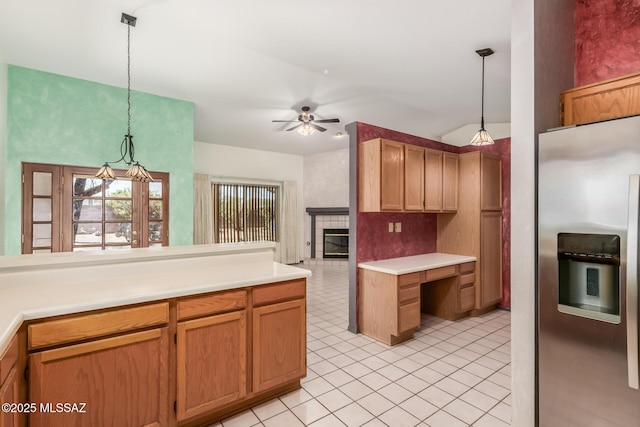 8410 E Heath Ct, Tucson, AZ 85715 - kitchen featuring stainless steel fridge with ice dispenser, ceiling fan, a fireplace, hanging light fixtures, and light countertops
