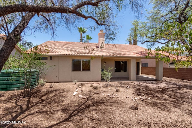 8410 E Heath Ct, Tucson, AZ 85715 - back of house featuring a tile roof, a chimney, stucco siding, and a patio area
