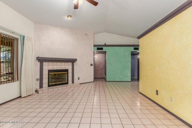 8410 E Heath Ct, Tucson, AZ 85715 - unfurnished living room featuring vaulted ceiling, a ceiling fan, a tiled fireplace, and tile patterned flooring