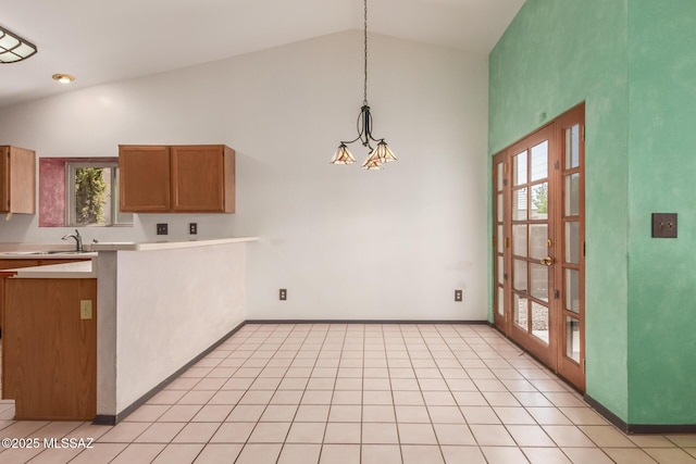 8410 E Heath Ct, Tucson, AZ 85715 - kitchen featuring light countertops, plenty of natural light, brown cabinets, decorative light fixtures, and high vaulted ceiling