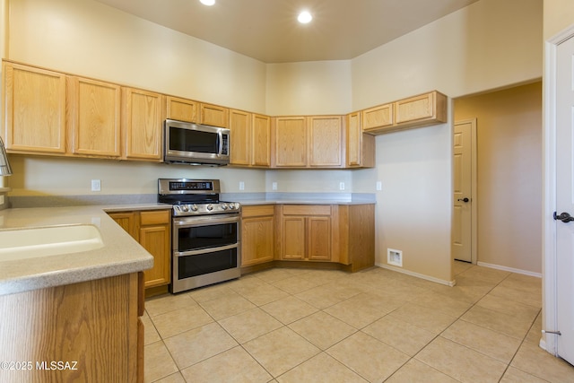 17160 W Starr Rd, Marana, AZ 85653 - kitchen featuring stainless steel appliances, light tile patterned floors, light countertops, light brown cabinetry, and recessed lighting