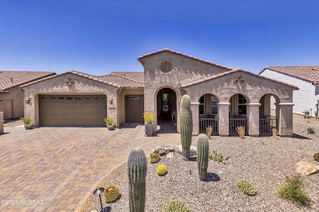 60048 E Peppertree Ln, Oracle, AZ 85623 - mediterranean / spanish-style home featuring a garage, stucco siding, decorative driveway, and a tile roof