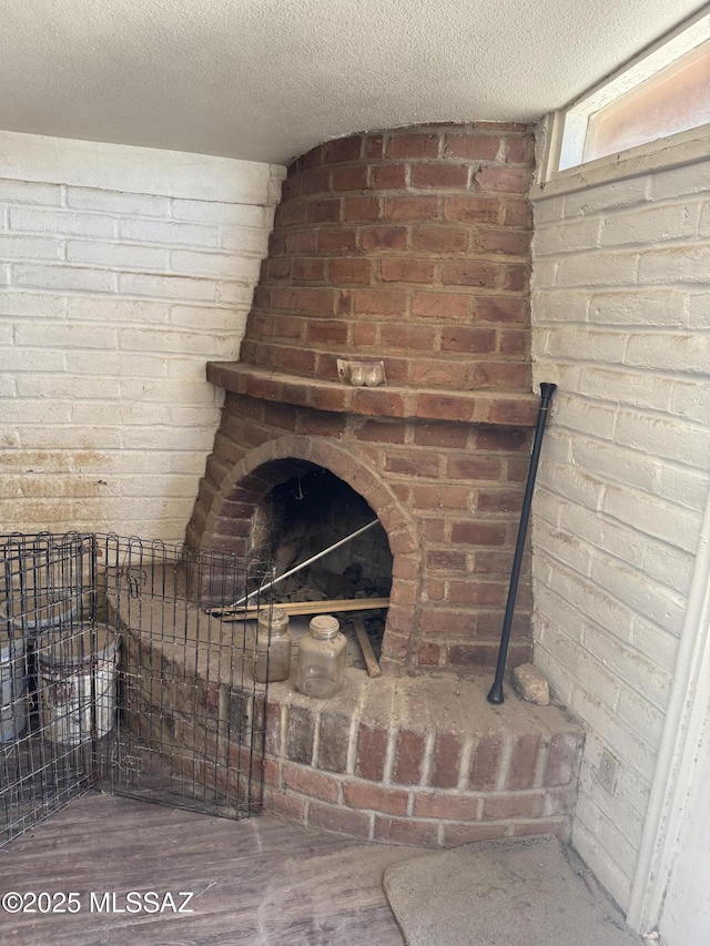 206 W Blacklidge Dr, Tucson, AZ 85705 - detailed view of wood finished floors, a textured ceiling, and brick wall