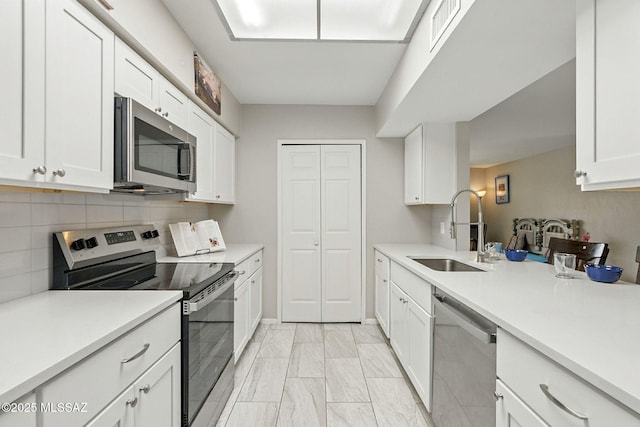 4211 N Villas Placitas, Tucson, AZ 85705 - kitchen with appliances with stainless steel finishes, light marble finish floors, white cabinetry, decorative backsplash, and light countertops