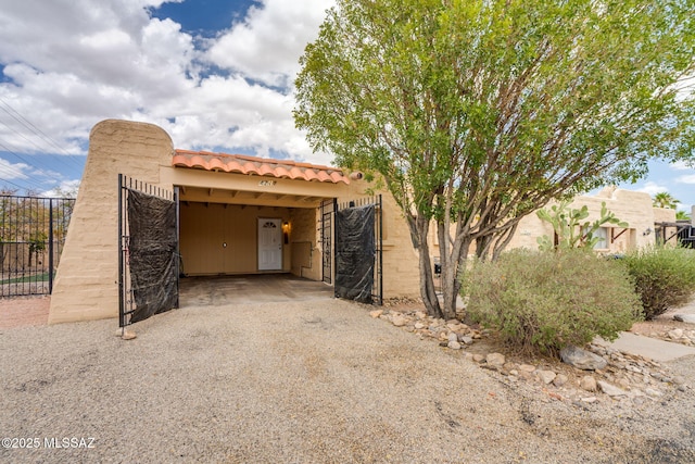 4211 N Villas Placitas, Tucson, AZ 85705 - view of front facade featuring gravel driveway, a tiled roof, stucco siding, and an attached carport