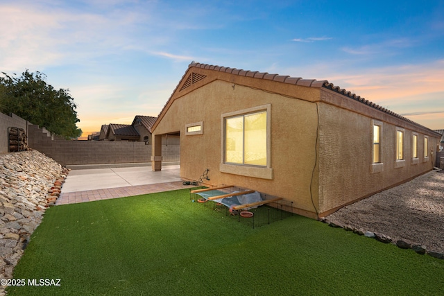 8035 S Talaco Trl, Tucson, AZ 85756 - back of house at dusk featuring a patio, a fenced backyard, and stucco siding