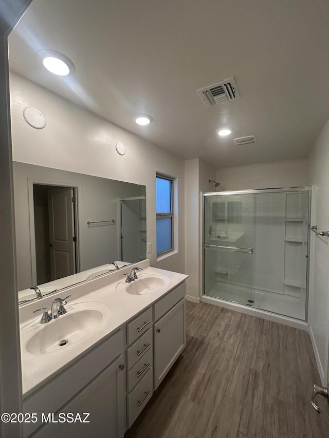 1126 E Descent St, Tucson, AZ 85719 - bathroom featuring double vanity, wood finished floors, a shower stall, and recessed lighting