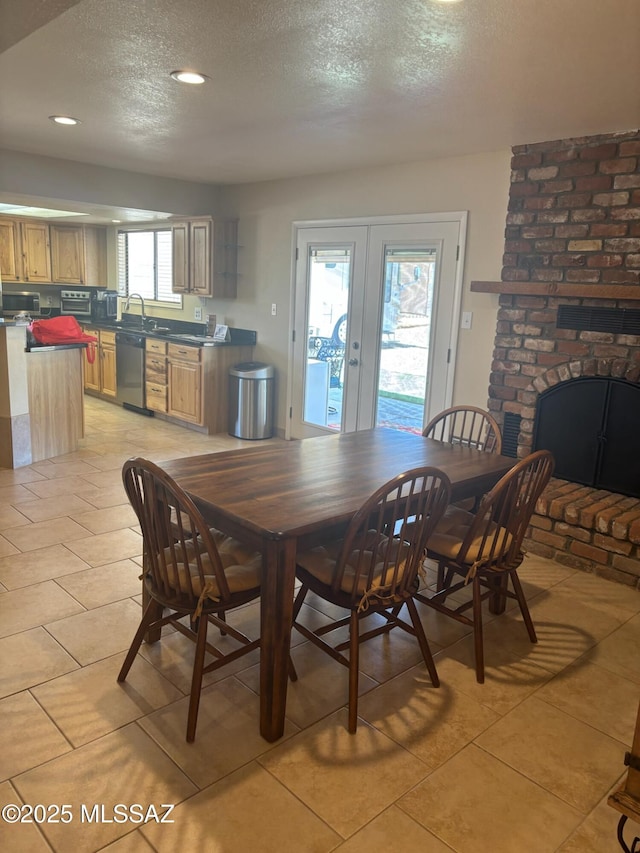6100 N La Canada Dr, Tucson, AZ 85704 - dining space featuring a textured ceiling, french doors, light tile patterned floors, recessed lighting, and a fireplace