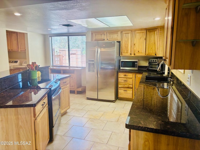 6100 N La Canada Dr, Tucson, AZ 85704 - kitchen featuring stainless steel appliances, separate washer and dryer, dark stone countertops, a center island, and recessed lighting