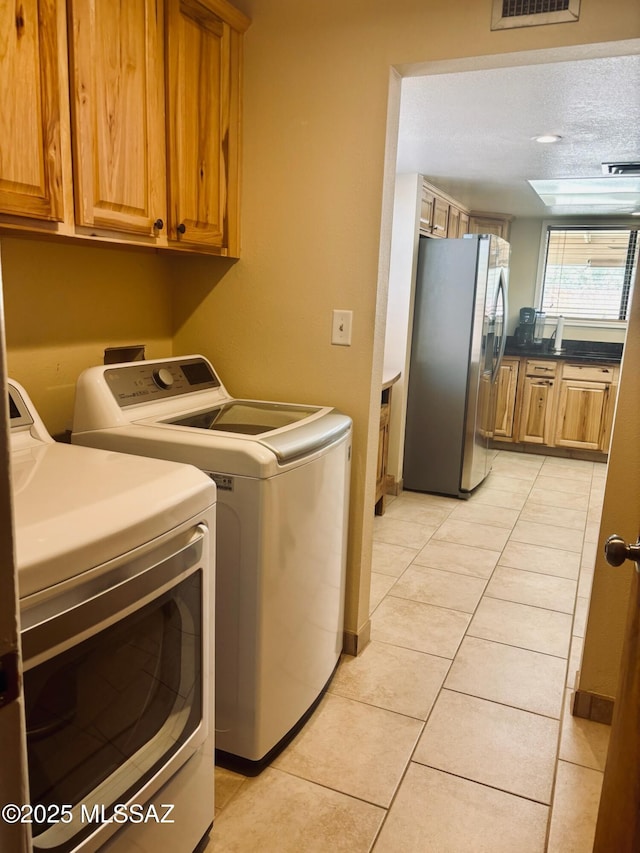 6100 N La Canada Dr, Tucson, AZ 85704 - washroom with independent washer and dryer, cabinet space, and light tile patterned floors