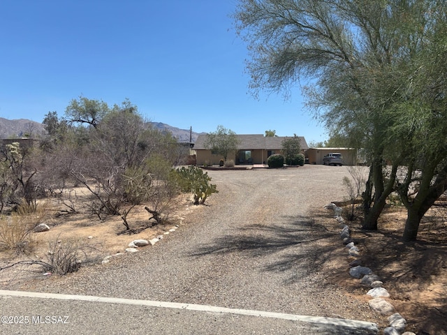 6100 N La Canada Dr, Tucson, AZ 85704 - view of front of property with dirt driveway, a mountain view, and stucco siding
