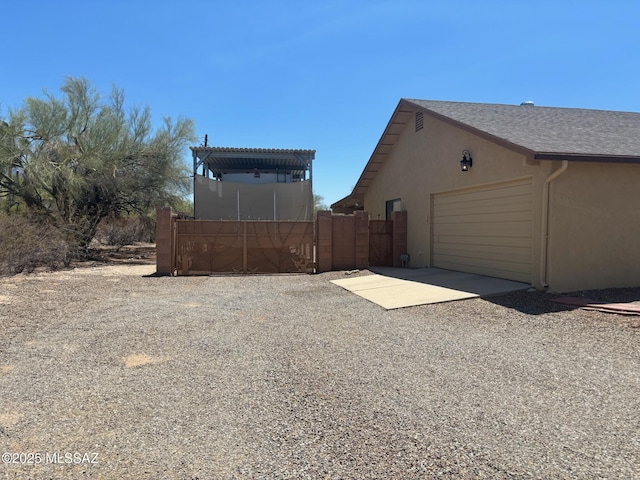 6100 N La Canada Dr, Tucson, AZ 85704 - view of home's exterior with driveway, a gate, and stucco siding