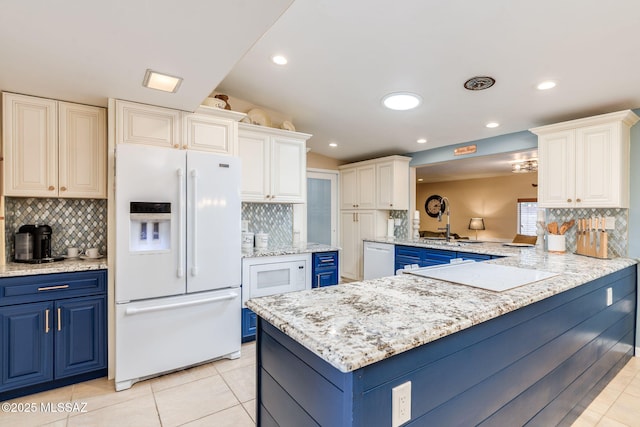 6951 E Hayne Pl, Tucson, AZ 85710 - kitchen with white appliances, blue cabinetry, tasteful backsplash, and recessed lighting