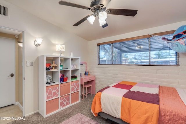 6951 E Hayne Pl, Tucson, AZ 85710 - carpeted bedroom with brick wall, multiple windows, vaulted ceiling, and a ceiling fan