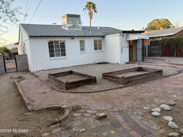 1412 E Silver St, Tucson, AZ 85719 - rear view of property with brick siding, roof with shingles, a gate, and a garden