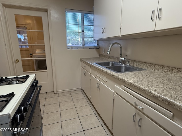 1412 E Silver St, Tucson, AZ 85719 - kitchen with black gas range, white cabinetry, light countertops, light tile patterned floors, and washer / clothes dryer