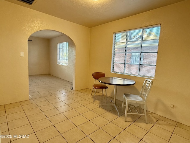 1412 E Silver St, Tucson, AZ 85719 - dining area with arched walkways, light tile patterned floors, a textured wall, and a textured ceiling
