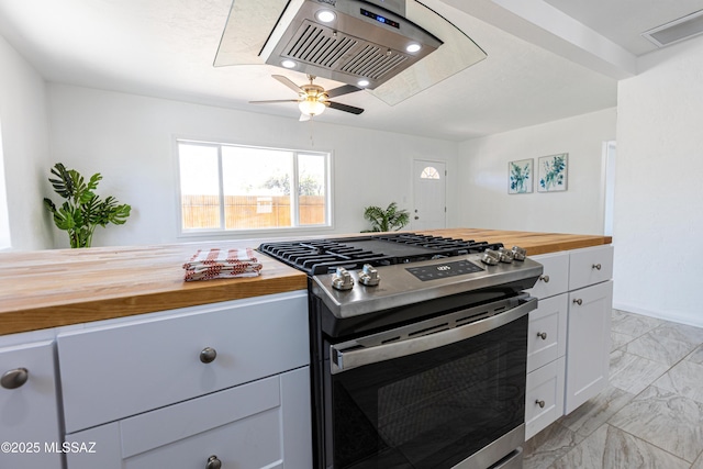 1435 E Grant Rd, Tucson, AZ 85719 - kitchen with butcher block countertops, stainless steel gas range oven, light marble finish flooring, white cabinetry, and a ceiling fan