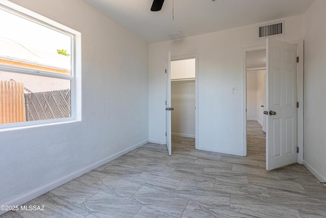 1435 E Grant Rd, Tucson, AZ 85719 - unfurnished bedroom featuring a closet, marble look tile flooring, and ceiling fan
