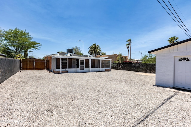 1435 E Grant Rd, Tucson, AZ 85719 - rear view of house featuring a sunroom, a fenced backyard, and brick siding