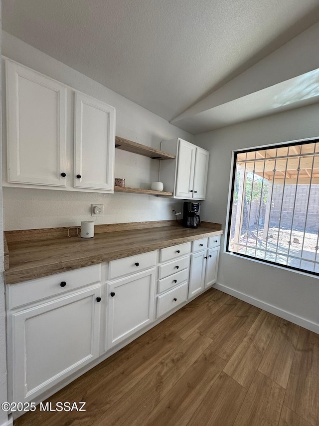 1129 W Amberbrooke Ave, Tucson, AZ 85745 - kitchen with wooden counters, open shelves, white cabinetry, dark wood-style floors, and vaulted ceiling