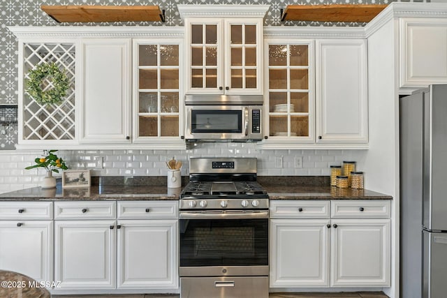 7705 W Taltson Dr, Tucson, AZ 85743 - kitchen featuring appliances with stainless steel finishes, white cabinets, tasteful backsplash, and glass insert cabinets