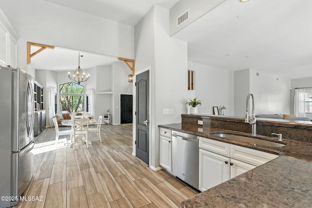 7705 W Taltson Dr, Tucson, AZ 85743 - kitchen with appliances with stainless steel finishes, open floor plan, plenty of natural light, and white cabinetry