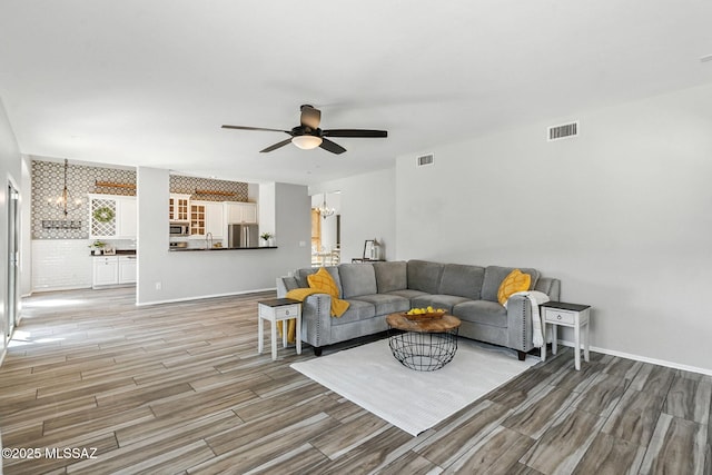 7705 W Taltson Dr, Tucson, AZ 85743 - living room featuring a chandelier, ceiling fan, and light wood-style floors