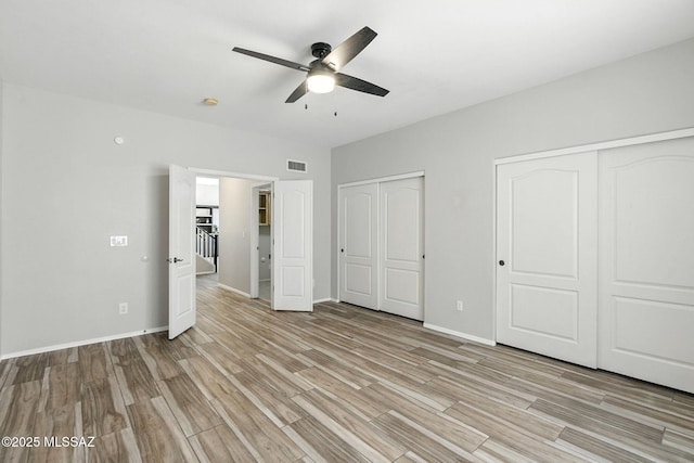 7705 W Taltson Dr, Tucson, AZ 85743 - unfurnished bedroom with multiple closets, light wood-type flooring, and ceiling fan