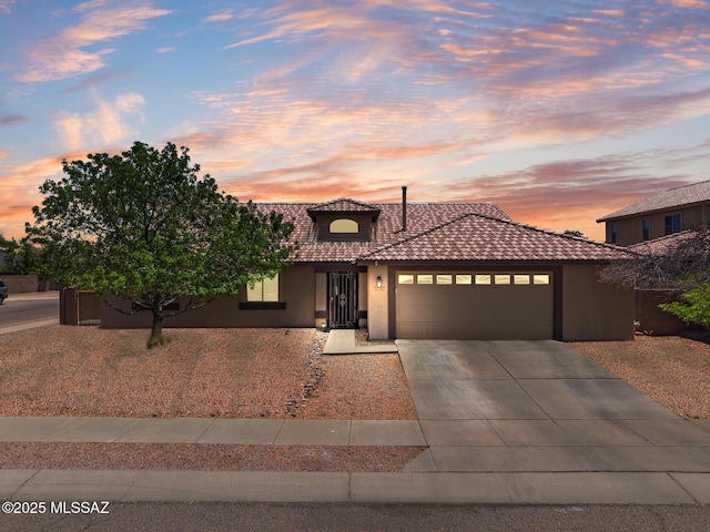 10636 E Malta St, Tucson, AZ 85747 - view of front facade featuring an attached garage, a tile roof, concrete driveway, and stucco siding