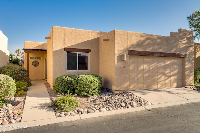 4352 E Haven Ln, Tucson, AZ 85712 - pueblo revival-style home with stucco siding, an attached garage, and concrete driveway