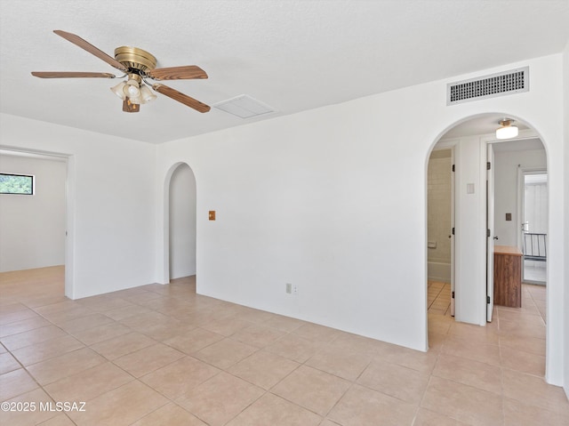 2638 N Wilson Ave, Tucson, AZ 85719 - empty room with arched walkways, a ceiling fan, and light tile patterned flooring