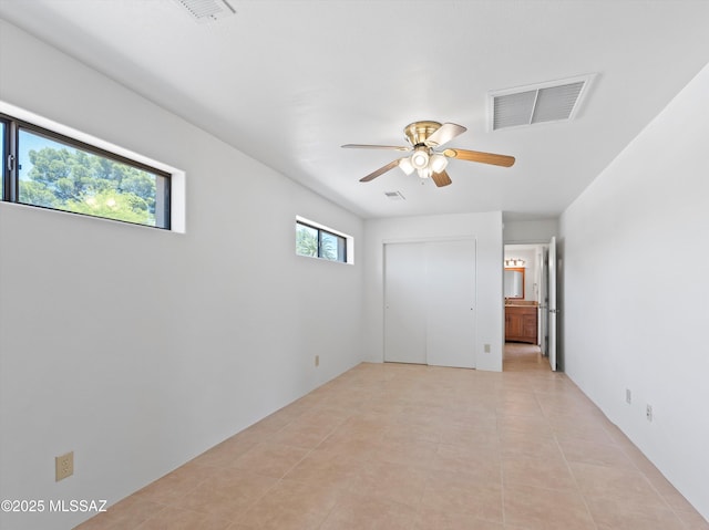 2638 N Wilson Ave, Tucson, AZ 85719 - unfurnished bedroom featuring ensuite bathroom, light tile patterned flooring, ceiling fan, and a closet