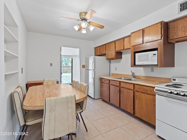 2638 N Wilson Ave, Tucson, AZ 85719 - kitchen with white appliances, light countertops, brown cabinetry, and a ceiling fan