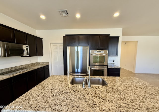 8361 N Mountain Stone Pine Way, Tucson, AZ 85743 - kitchen with appliances with stainless steel finishes, light stone counters, dark brown cabinets, and recessed lighting