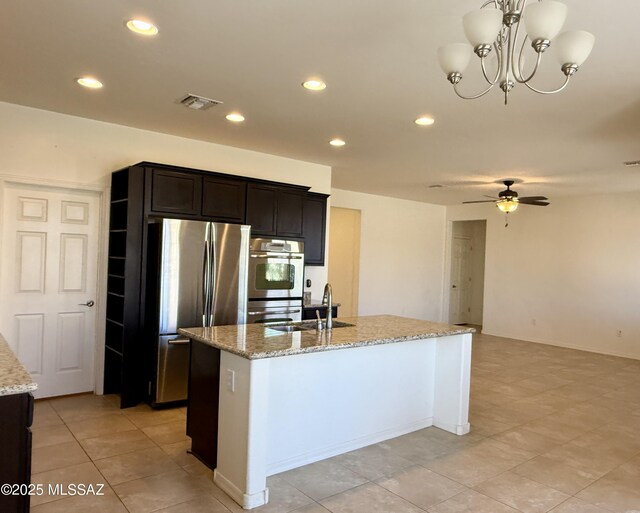 8361 N Mountain Stone Pine Way, Tucson, AZ 85743 - kitchen featuring appliances with stainless steel finishes, a kitchen island with sink, light stone counters, ceiling fan, and recessed lighting