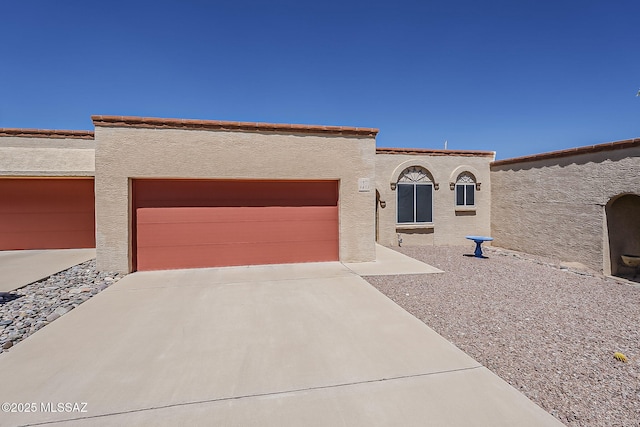 9453 E Calle Bolivar, Tucson, AZ 85715 - mediterranean / spanish-style house featuring an attached garage, concrete driveway, and stucco siding