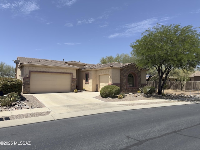 13049 N Woosnam Way, Oro Valley, AZ 85755 - view of front of house featuring an attached garage, stone siding, stucco siding, and concrete driveway