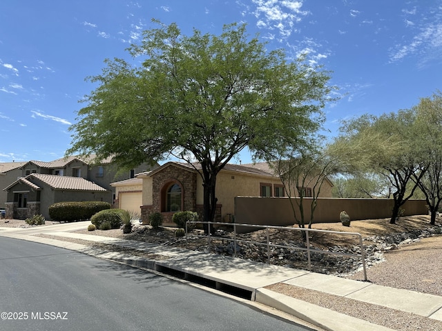 13049 N Woosnam Way, Oro Valley, AZ 85755 - view of front of property featuring stucco siding, a garage, and stone siding