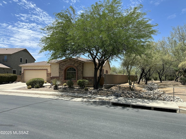 13049 N Woosnam Way, Oro Valley, AZ 85755 - view of front of home with a garage, stucco siding, stone siding, and driveway